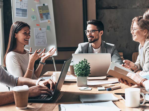 team smiling gathered around conference table