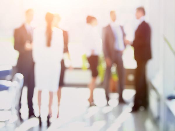 6 people standing in a bright room