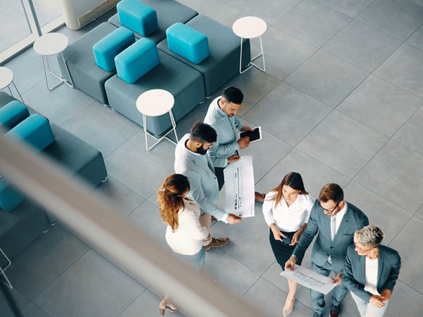 Group of professionals standing in the office area looking at plans
