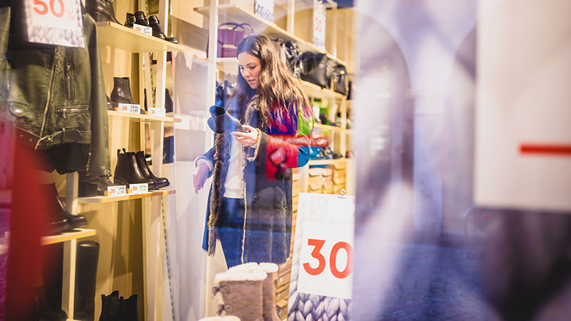 Woman looking closely at a boot in a shoe store