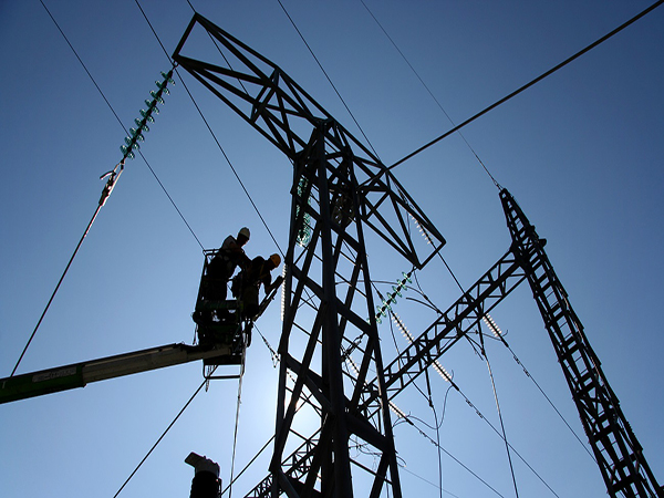 Utility workers using a lift to work on power lines