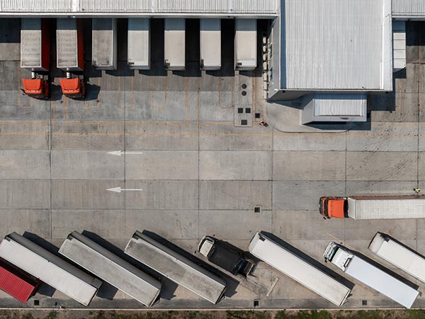 birds eye view of semi trucks parked at a warehouse