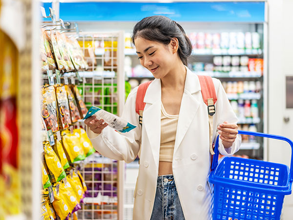 Young asian woman buy snacks and dried fruits at store