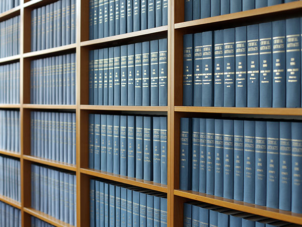 photo of a wall of shelves filled with volumes of a reference library