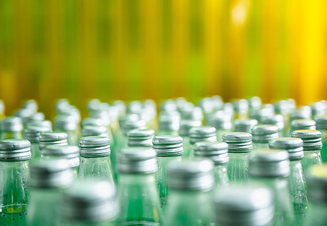 close-up photo of glass bottles on a production line
