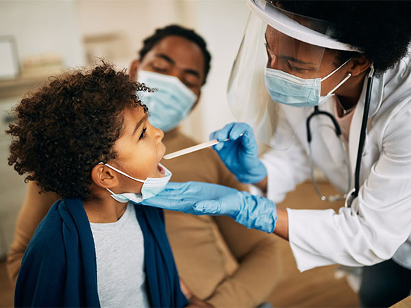 Child being examined by a medical professional while sitting on his parent's lap