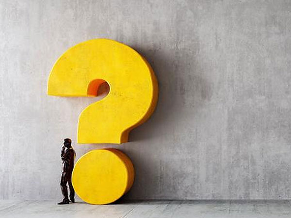 Statue of man thinking next to a large yellow question mark.