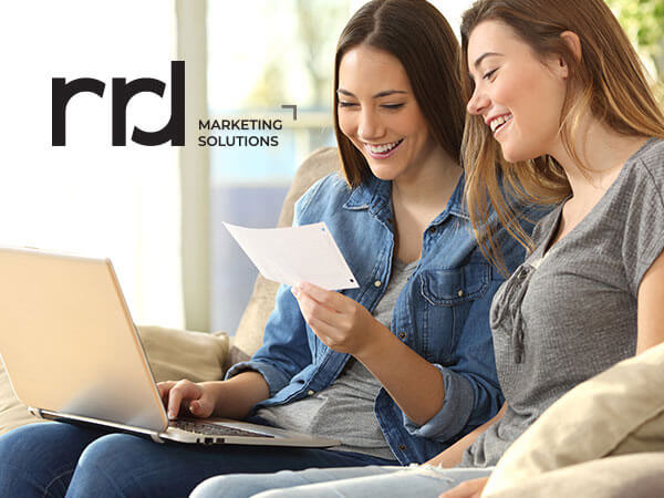 sisters sitting on couch looking at piece of paper