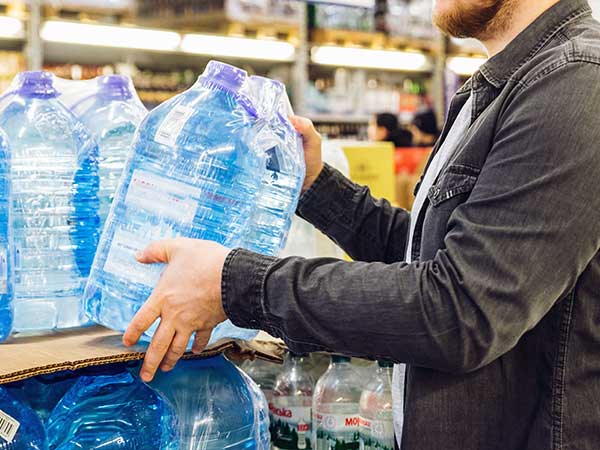 man take water from the shelf of the store