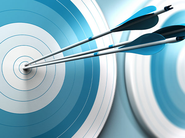 close up of three arrows piercing the bullseye of a target