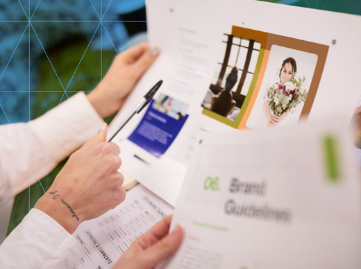 Person reviewing printed marketing materials with images and text.