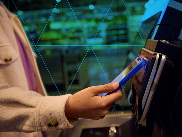 person using a smartphone to pay at a cash register
