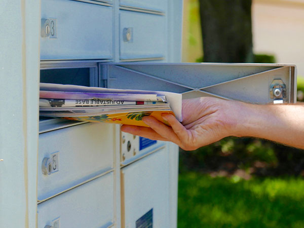 photograph of a hand pulling mail out of a mailbox
