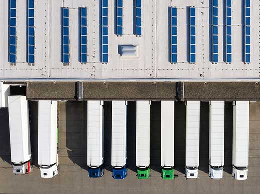 bird's eye view of several trucks backed into a loading dock