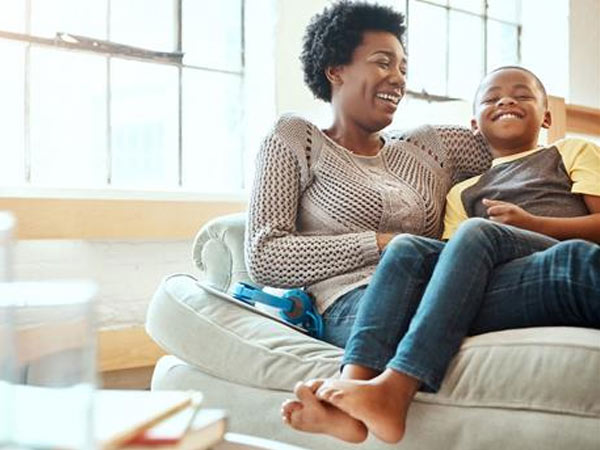 Mom snuggling son on couch