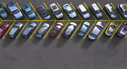aerial view of a parking lot lane, each spot filled with a different car