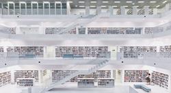 four floors of interior of a library with white floors, railings, shelves, and colorful books