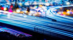 city highway at night with light trails on the road signifying movement