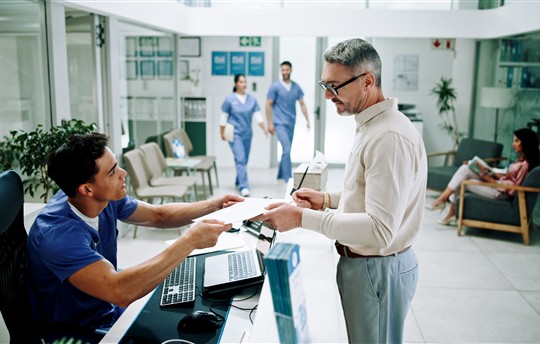 Hospital, nurse and man at front desk with paperwork for appointment, consultation