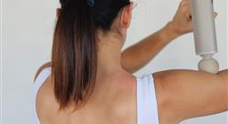 Person using a massage device to relieve tension on the shoulder and back at home concept