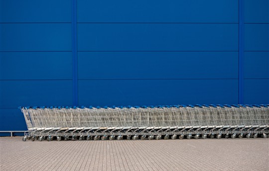 row of grocery carts against a blue wall