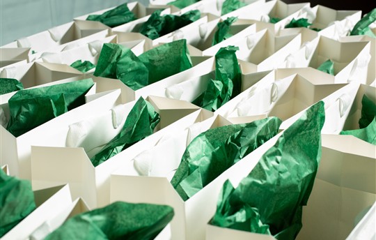 A view of several paper goodie bags with tissue paper