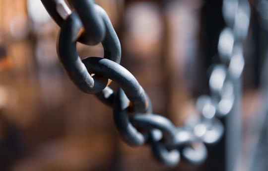 Thick metal chain on dark background