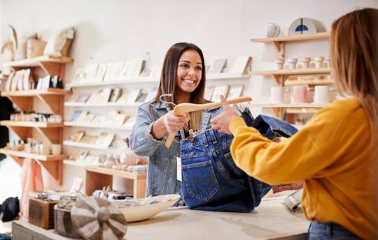 Female Sales Assistant In Independent Clothing And Gift Store Serving Female Customer