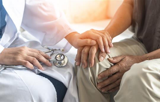 doctor with hand on patient's hand