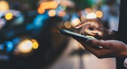 Businesswoman with smartphone using application for calling taxi online walking on city street night