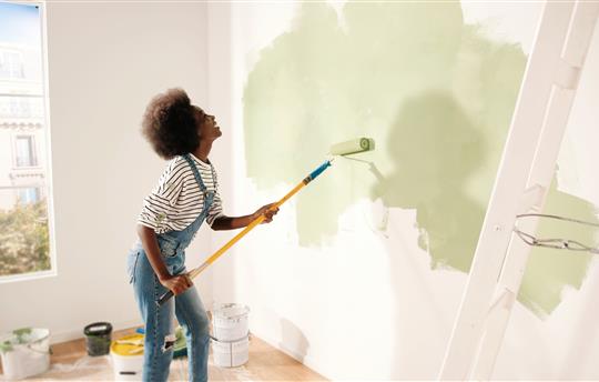 woman painting room green