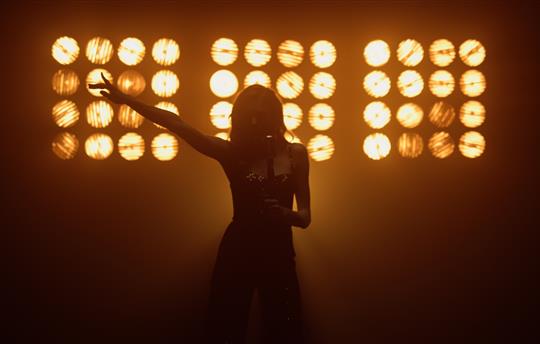 female singer on stage, silhouette