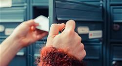 person in sweater opening blue mailbox