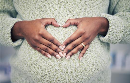 Pregnancy, closeup and woman with a heart shape on her maternal belly for care and motherhood
