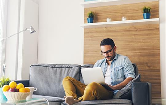 man on a couch using a laptop