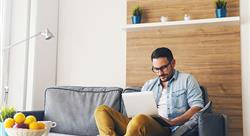 man on a couch using a laptop