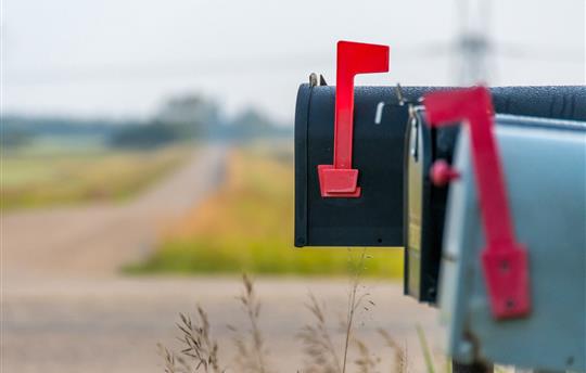 three closed mailboxes at the side of the road