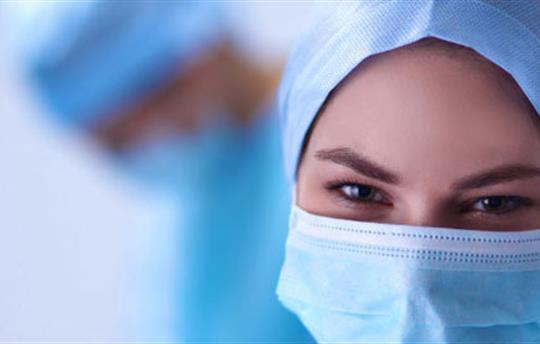 close up of female healthcare worker wearing a blue mask