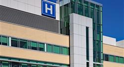 exterior view of a hospital with blue H hospital sign