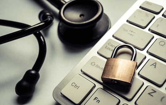close up of a small lock on top of a keyboard with a stethoscope next to it