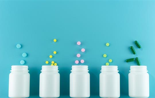 Medicines, supplements and drugs in a bottle on blue background