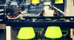 Interior of a modern fast food restaurant with bright green chairs