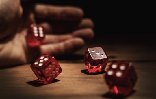 Gaming dice being rolled by hand
