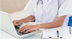 Doctor typing on laptop, clipboard with paperwork placed next to her