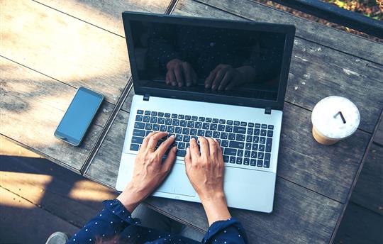 woman with hands on laptop keys