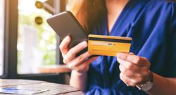 Closeup image of woman in blue dress using credit card for purchasing and shopping online on mobile phone