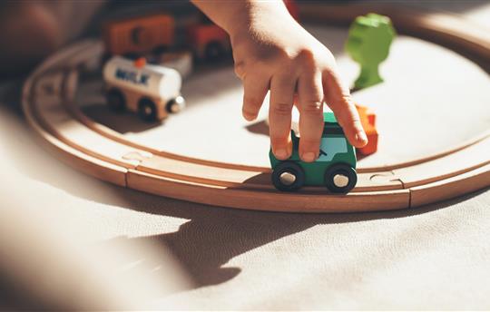 Kid playing with train on track