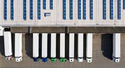 Aerial view of large semi trucks parked along warehouse-distribution center