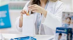 female pharmacist placing medication in a white paper bag