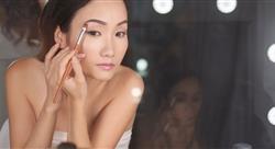 woman looking into a vanity mirror putting on eye shadow